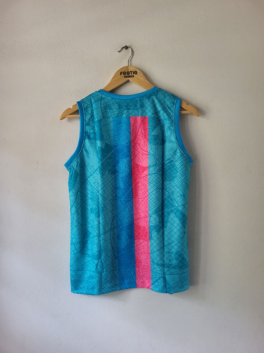 A sleeveless athletic tank top hanging on a wooden hanger against a plain beige wall. The top is bright turquoise blue with a subtle geometric pattern and features a prominent vertical pink stripe down the center.
