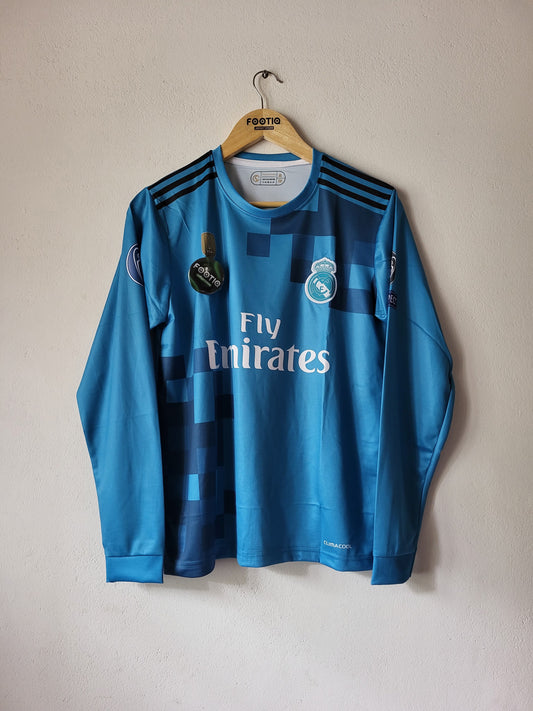 Blue sports jersey with Emirates logo on a beige background