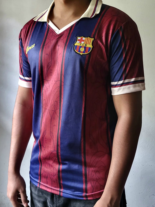 A person wearing a vintage-style FC Barcelona soccer jersey with vertical red and blue stripes, a cream collar, and the club crest on the chest.