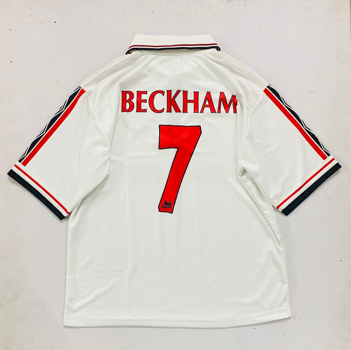 White sports jersey with 'BECKHAM' and number '7' on a white background