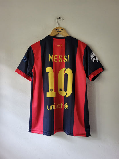 A red and navy blue FC Barcelona soccer jersey with 'MESSI 10' printed on the back, hanging on a wooden hanger against a plain wall.