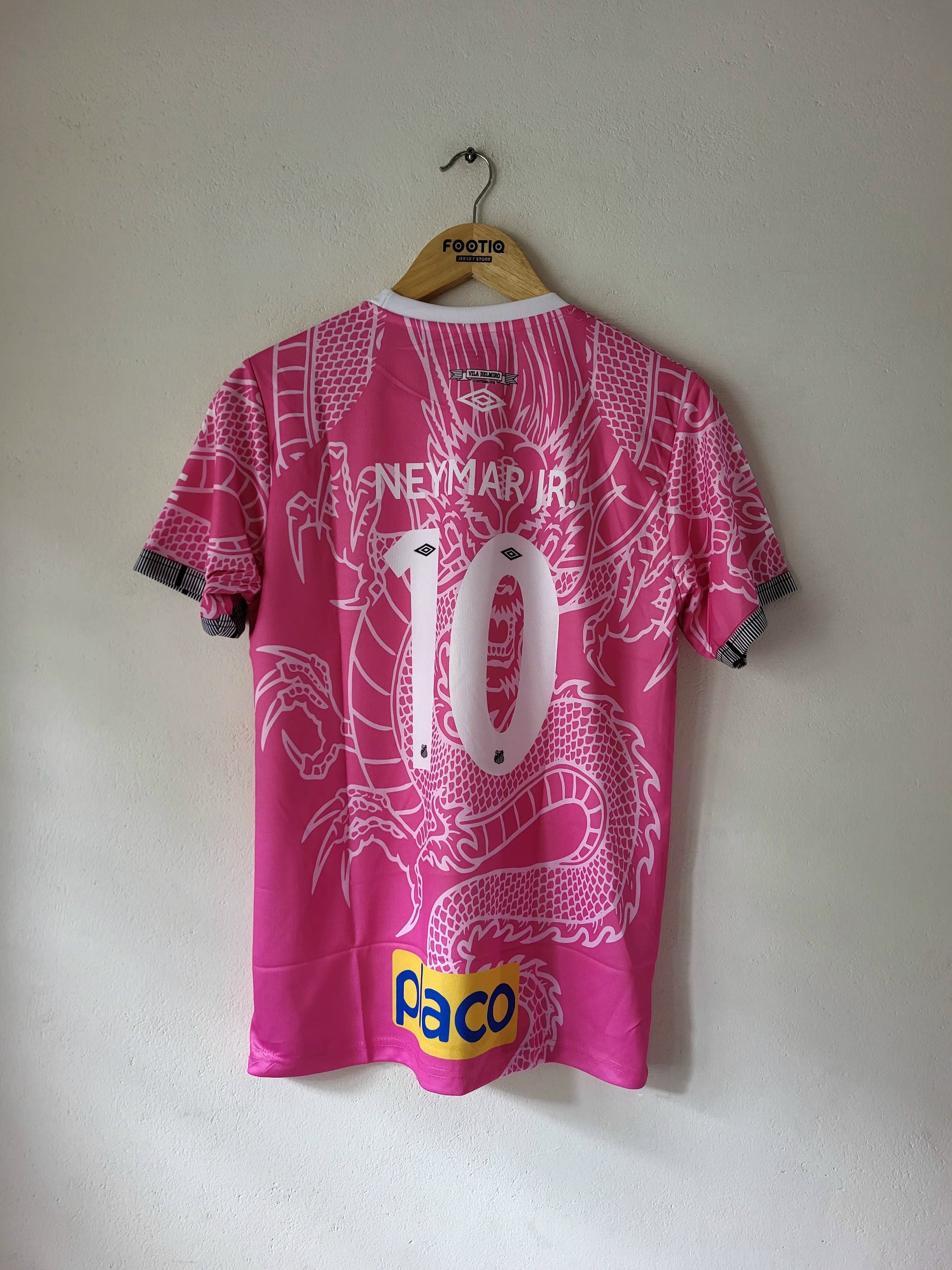 Pink Neymar Jr. number 10 soccer jersey with a white dragon graphic, hanging on a wooden hanger against a plain wall.