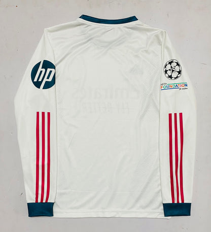White long-sleeve soccer jersey laid flat on a light gray background, featuring dark teal collar and cuffs, red three-stripe detailing on the sleeves, an HP logo on the right sleeve, a Champions League patch on the left sleeve, and a Foundation by Adidas logo.