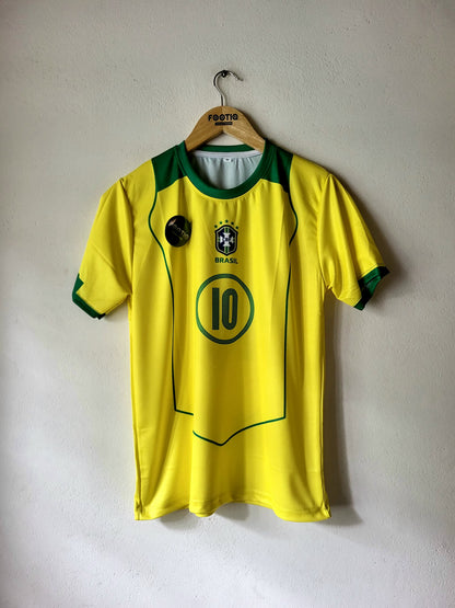 A yellow Brazil national team soccer jersey with green trim, featuring the number 10 on the front, hanging on a wooden hanger against a plain wall.