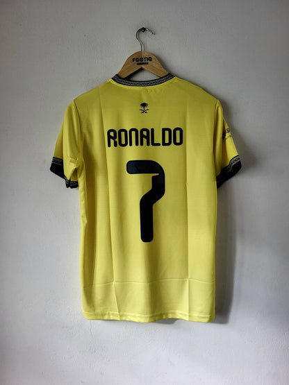 A yellow soccer jersey with 'RONALDO' and the number '7' printed in black on the back, hanging on a wooden hanger against a plain light gray wall.