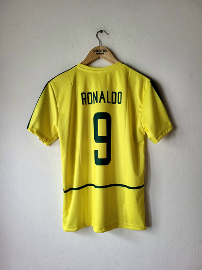 A yellow soccer jersey with 'RONALDO' and the number '9' printed in green on the back, hanging on a wooden hanger against a plain light gray wall.