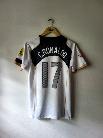 A white and black C.Ronaldo soccer jersey with the number 17 on the back, hanging on a wooden hanger against a light gray wall.