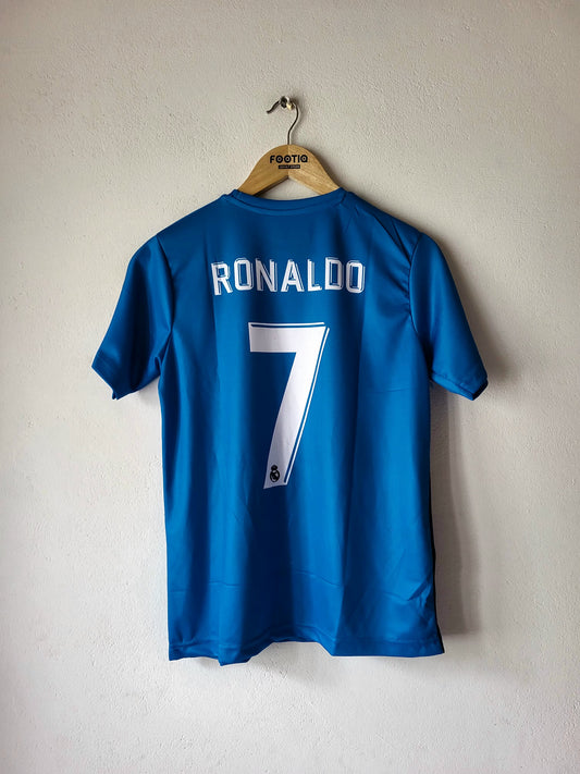 A blue soccer jersey with 'RONALDO' and the number '7' printed in white on the back, hanging on a wooden hanger against a textured off-white wall.