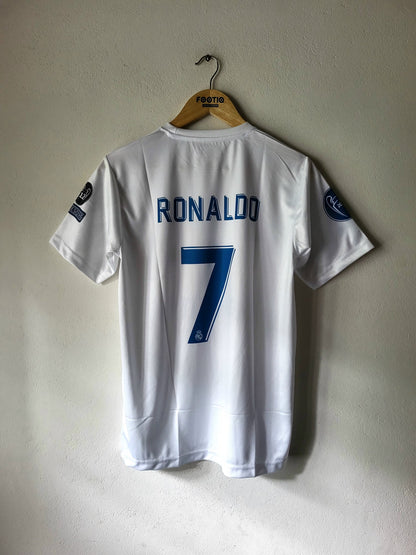 A white Sporting CP soccer jersey with 'RONALDO' and the number '7' printed in blue on the back, hanging on a wooden hanger against a textured off-white wall.