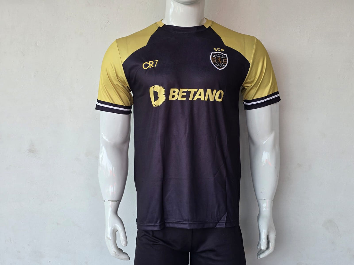 A dark navy and gold soccer jersey displayed on a white mannequin. The jersey features gold sleeves, a gold 'CR7' logo on the right chest, a gold crest on the left chest, and a prominent gold 'BETANC' sponsor logo across the center.