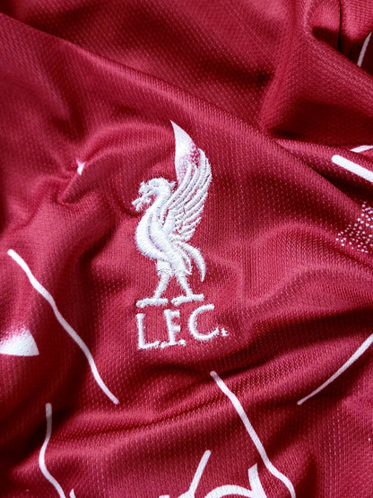 Close-up of a red textured fabric with a white embroidered Liverpool FC bird logo and 'LFC' text.