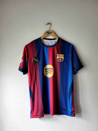 FC Barcelona home soccer jersey with blue and red vertical stripes, featuring the club crest and Spotify sponsor logo, hanging on a wooden hanger against a plain wall.