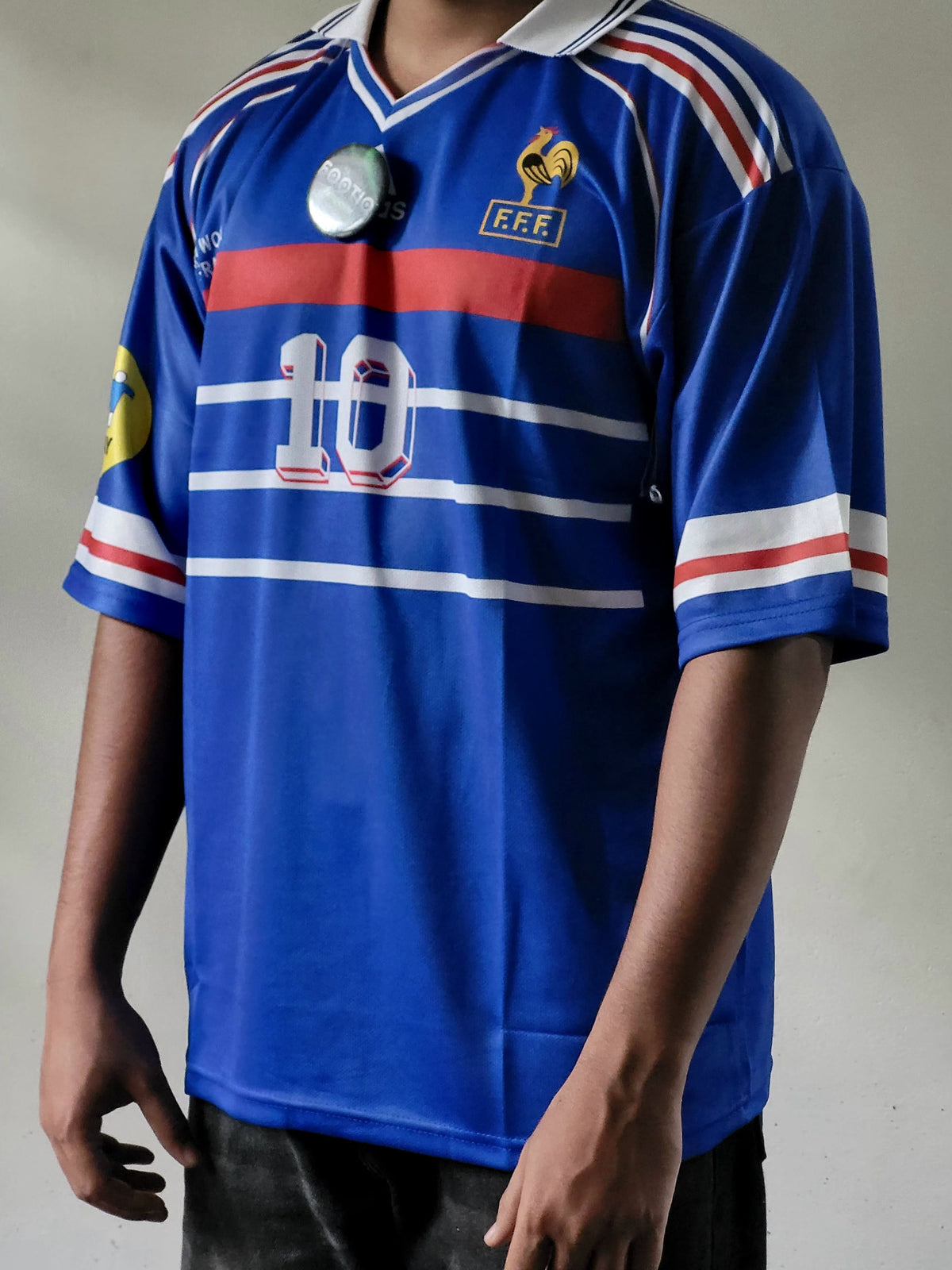 A person wearing a blue France national football team jersey with red and white stripes, featuring the number 10 on the front and F.F.
