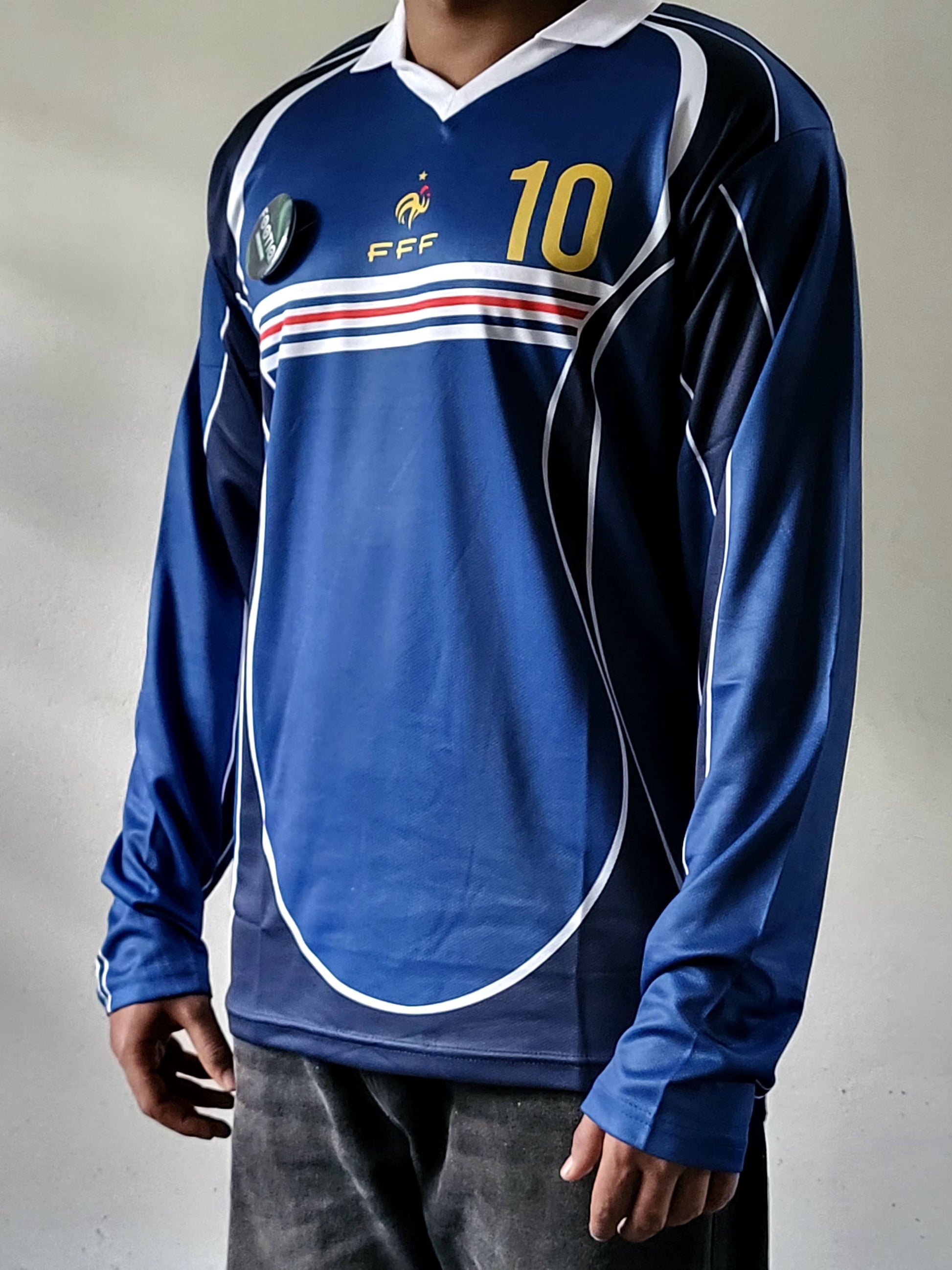 zidane full sleeve jersey, blue colour full sleeve, most selling,person wearing a blue long-sleeve soccer jersey with white, red, and yellow details, featuring the number 10 and FFF crest, paired with dark gray jeans.